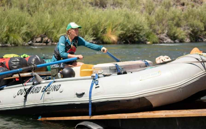 a person uses paddles to guide a raft off a trailer for an outward bound gap year expedition